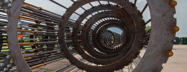 An anchor bolt cage laying on its side, showing steel rings and anchor bolts. 